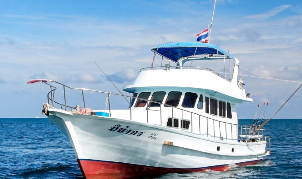 Phuket fishing boat, with gear set out and calm waters ahead promising a fruitful day